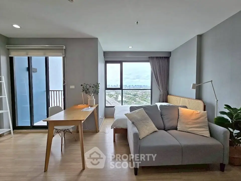 Modern studio apartment with city view, featuring cozy living area and stylish decor.