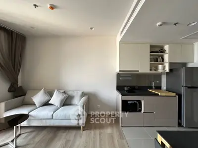 Modern living room with sleek kitchen, cozy sofa, and stylish decor