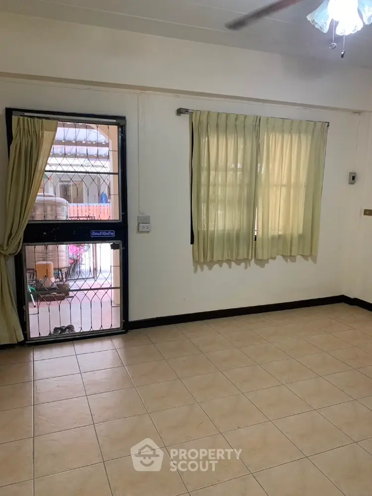 Spacious unfurnished room with tiled flooring and large windows for natural light.