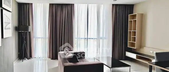 Spacious modern living room with large windows and elegant furnishings.