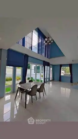 Spacious modern living room with high ceilings and large windows offering abundant natural light.