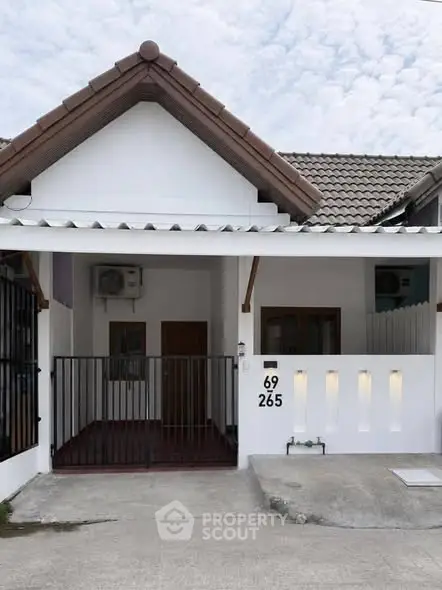 Charming single-story house with tiled roof and gated entrance, perfect for cozy living.