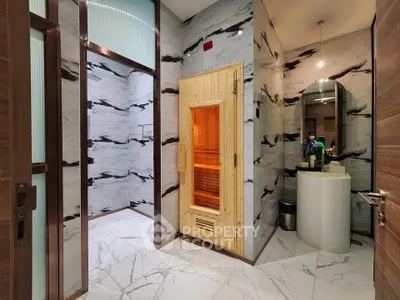 Luxurious spa-like bathroom with sauna and elegant marble design