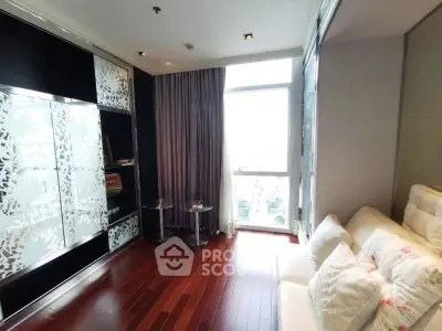 Elegant living room with hardwood floors and large window, featuring stylish decor and cozy seating.