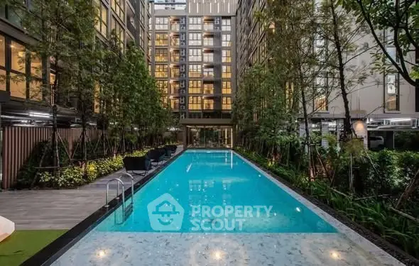 Luxurious modern apartment complex with a stunning outdoor pool and lush greenery.