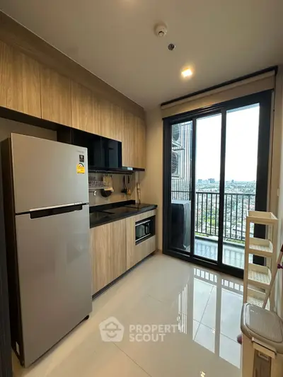 Modern kitchen with sleek appliances and balcony view in urban apartment