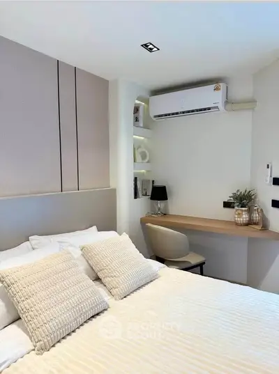 Modern bedroom with cozy decor and built-in desk, featuring air conditioning and stylish lighting.