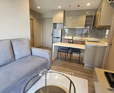 Modern open-layout living room and kitchen with sleek design and neutral tones.