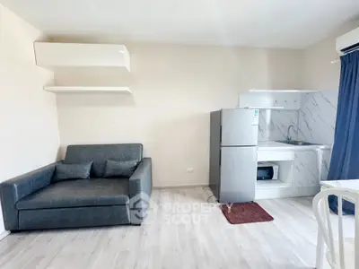 Modern studio apartment with sleek kitchen and cozy living area, perfect for urban living.
