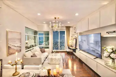 Luxurious living room with stunning city view, elegant chandelier, and modern decor in high-rise apartment.