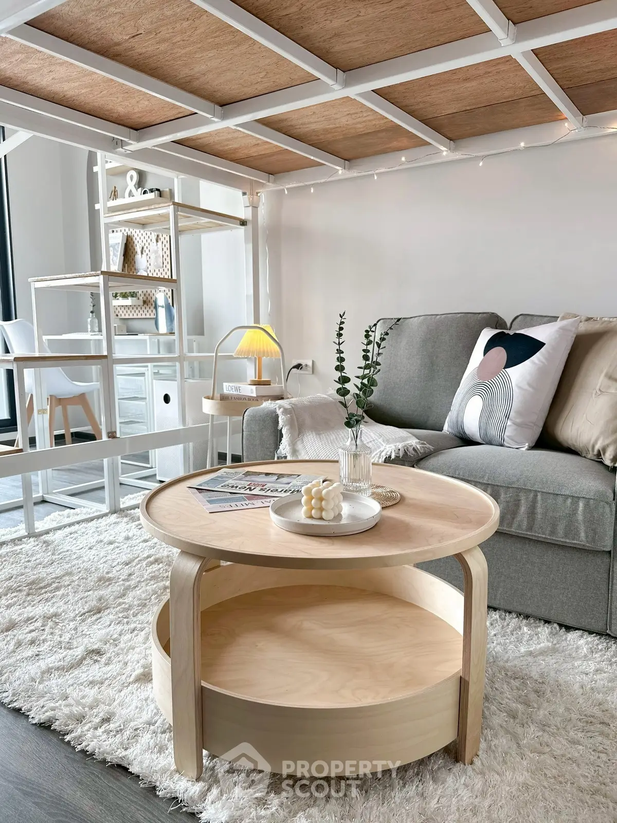 Modern living room with stylish furniture and cozy decor, featuring a round wooden coffee table and plush sofa.
