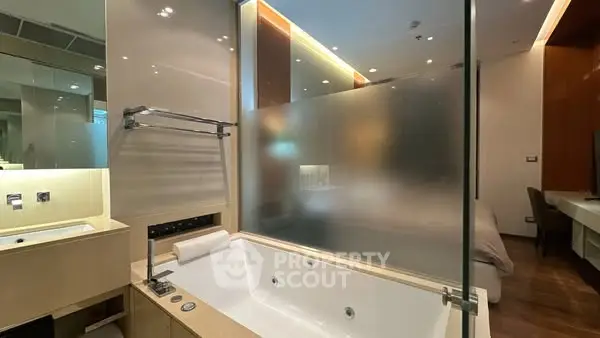Luxurious bathroom with modern bathtub and frosted glass partition
