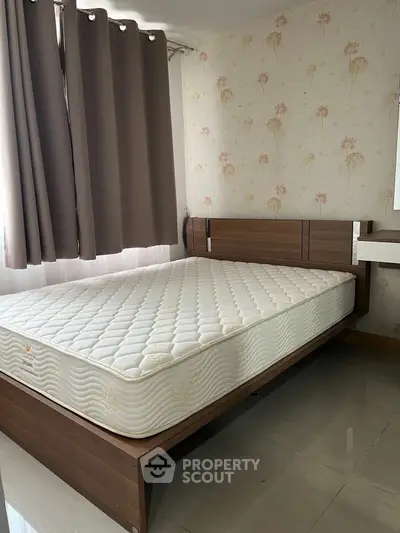 Cozy bedroom with modern bed frame and floral wallpaper, perfect for relaxation.