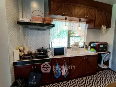Charming kitchen with wooden cabinets and modern appliances, featuring a cozy window view.