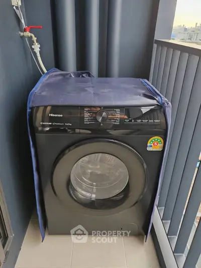 Modern washing machine on a compact balcony with city view, perfect for urban living convenience.