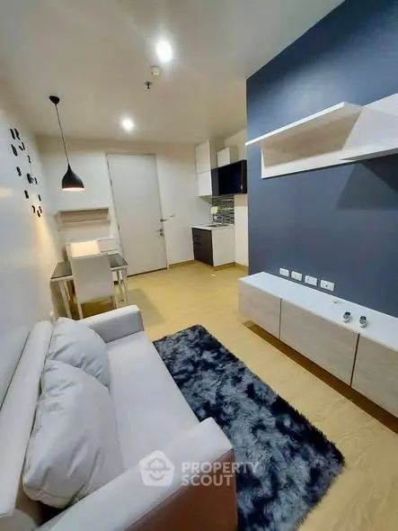 Modern living room with stylish decor and open kitchen layout in a cozy apartment.