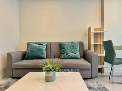 Modern living room with stylish gray sofa and green accents