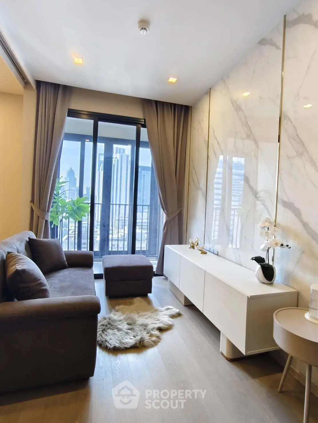 Luxurious living room with city view, elegant decor, and modern furnishings in high-rise apartment.