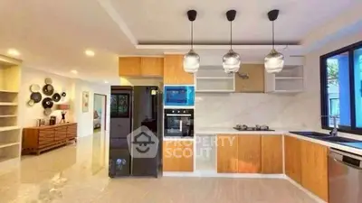 Modern kitchen with sleek appliances and open layout, featuring stylish pendant lighting.