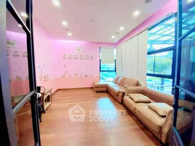 Charming living room with pink walls and cozy seating, perfect for relaxation.