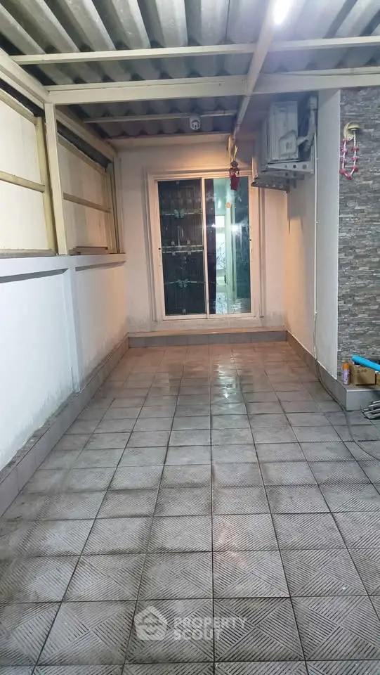 Spacious tiled balcony with sliding glass doors and air conditioning unit.