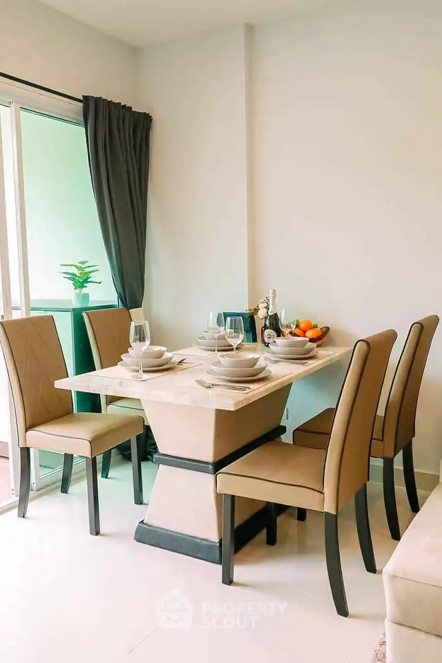 Stylish dining area with elegant table setting and modern chairs in a bright apartment.