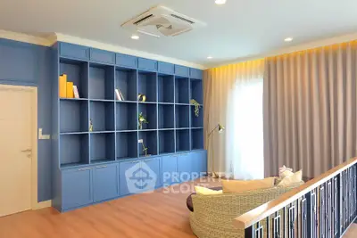 Spacious living room with blue built-in shelves and cozy seating area.