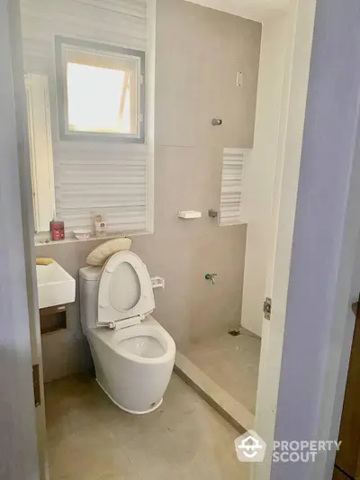 Bright and airy bathroom with modern fixtures, a large mirror, and a window allowing natural light to enhance the clean, minimalist design.