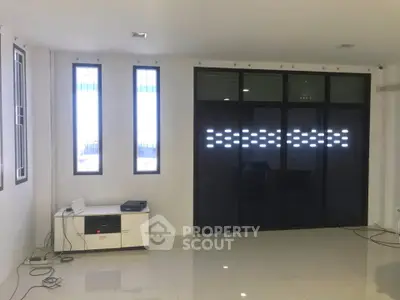 Spacious modern living room with sleek tiled flooring and large windows for natural light.