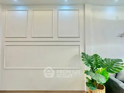 Elegant living room with modern wall paneling and lush indoor plant