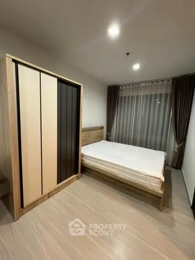 Modern bedroom with sleek wardrobe and large window for natural light