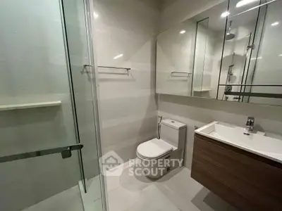 Modern bathroom with glass shower and sleek fixtures in a contemporary apartment.
