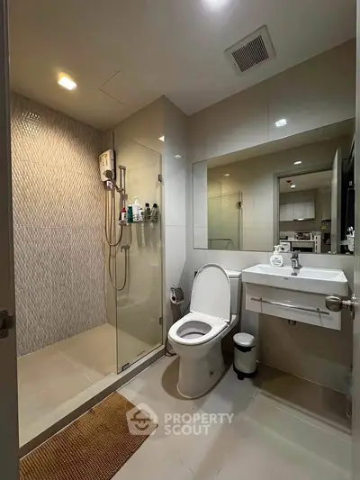 Modern bathroom with glass shower and sleek fixtures in a contemporary apartment.