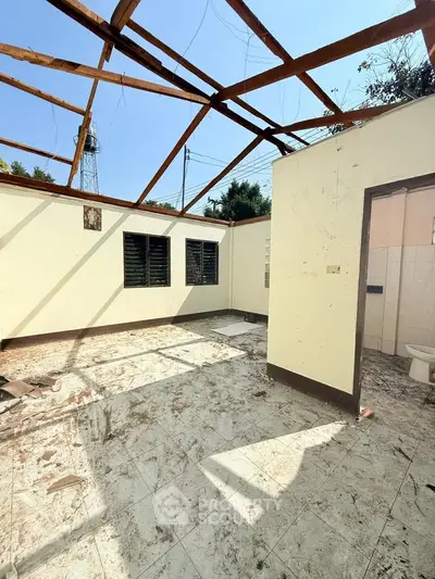 Partially constructed room with open roof and tiled floor, potential renovation project.