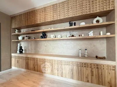 Elegant built-in wooden shelves with decorative items in a modern living room.
