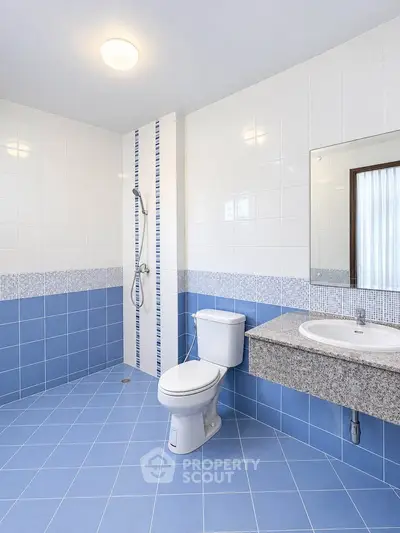 Spacious modern bathroom with blue tiles and sleek fixtures