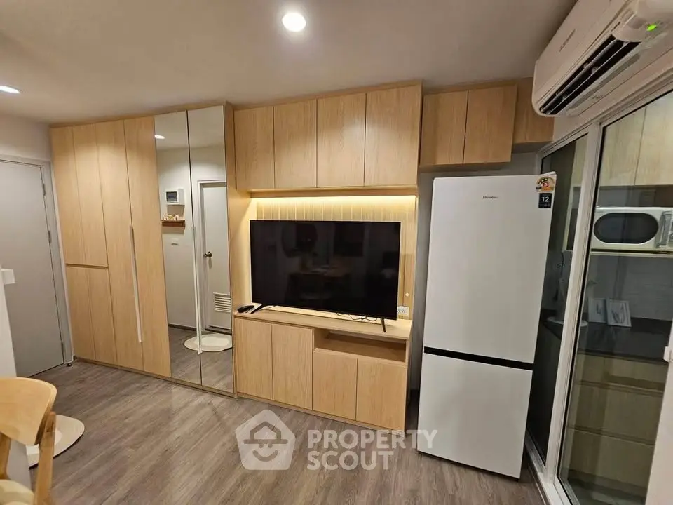 Modern living room with sleek wooden cabinetry and integrated appliances