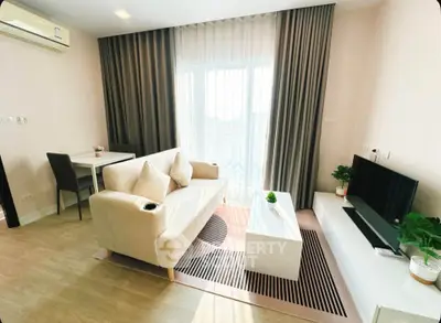 Modern living room with stylish furniture and large window offering natural light.
