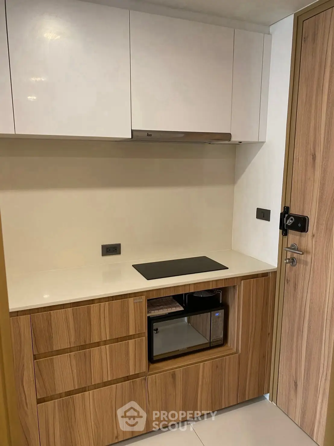 Modern compact kitchen with sleek wooden cabinets and built-in appliances