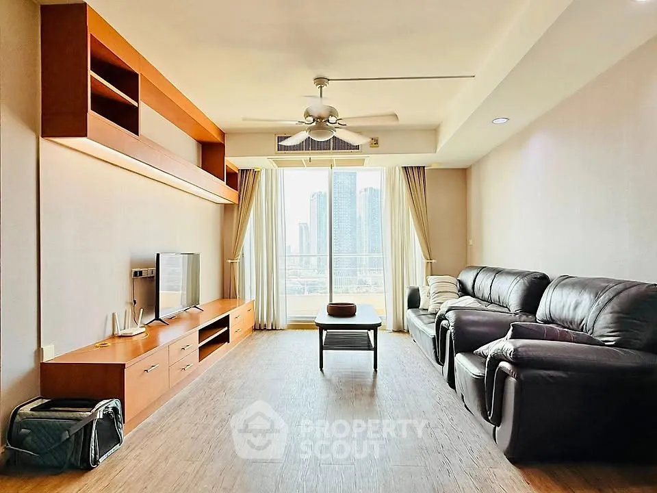 Spacious living room with modern furniture and city view, perfect for relaxation and entertainment.