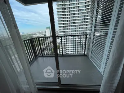 Modern high-rise balcony with city view and glass sliding doors