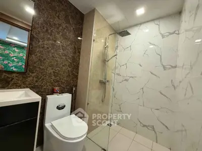 Modern bathroom with elegant marble tiles and glass shower enclosure