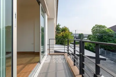 Spacious balcony with modern railing and scenic view of greenery and neighborhood.
