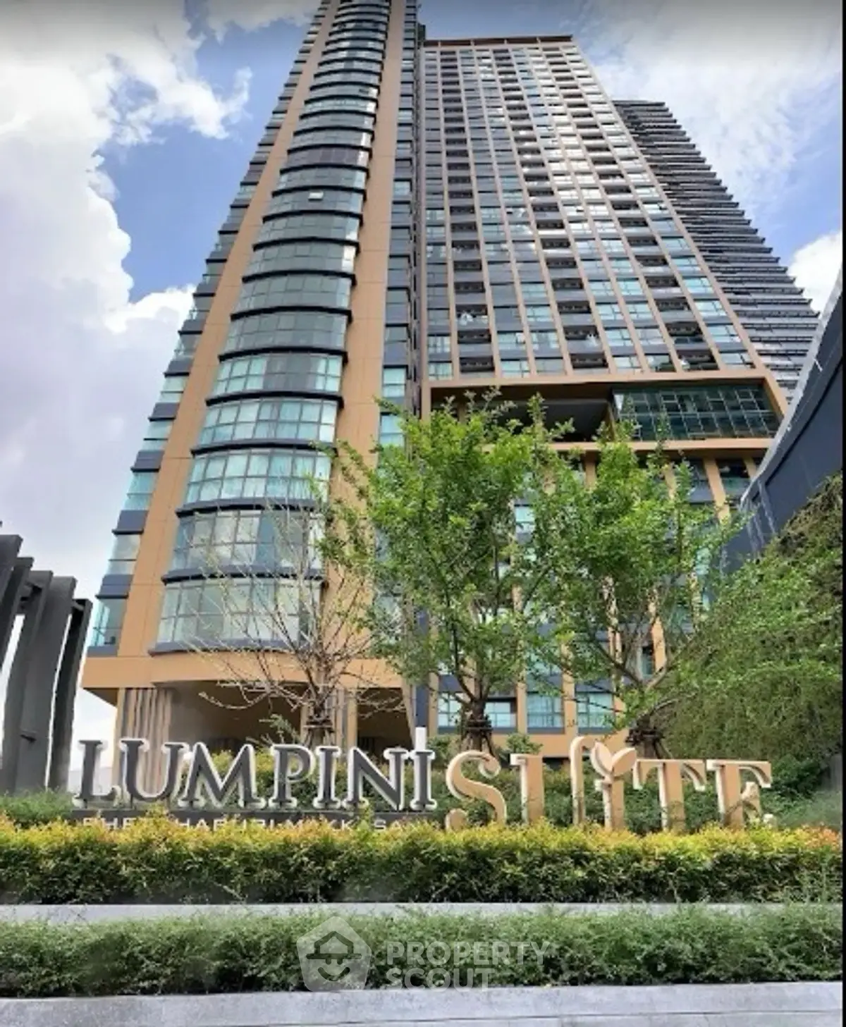 Stunning high-rise building exterior with lush greenery at Lumpini Suite.