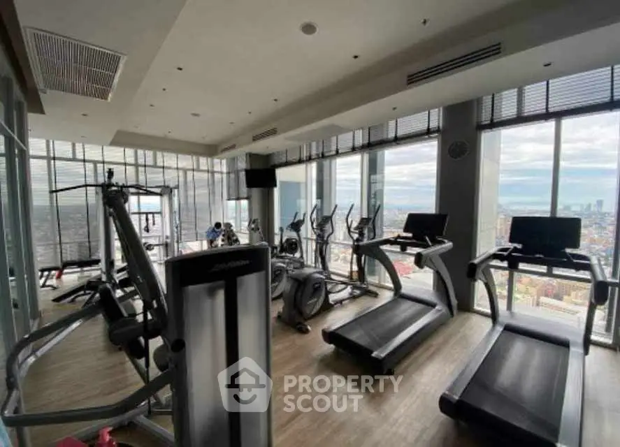 Modern gym with panoramic city views and state-of-the-art equipment.