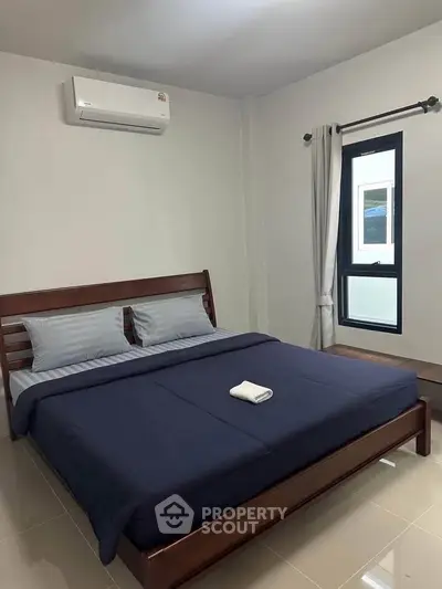Modern bedroom with sleek design, featuring a comfortable bed and air conditioning, perfect for relaxation.