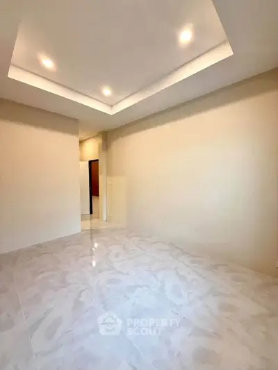 Spacious empty room with elegant recessed lighting and glossy tile flooring.