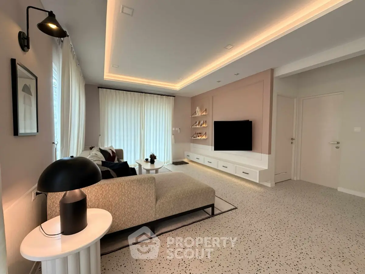 Modern living room with stylish decor and ambient lighting, featuring a cozy sofa and sleek entertainment unit.