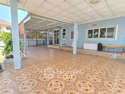 Spacious covered patio with decorative tile flooring and ample natural light, perfect for outdoor gatherings.