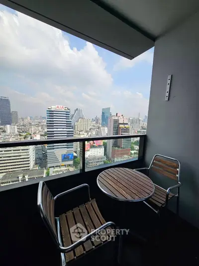 Stunning city view from a modern balcony with seating area, perfect for relaxation.